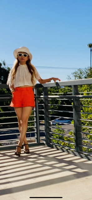how to style with a simple white loose  crop top example is wearing with colorful short
